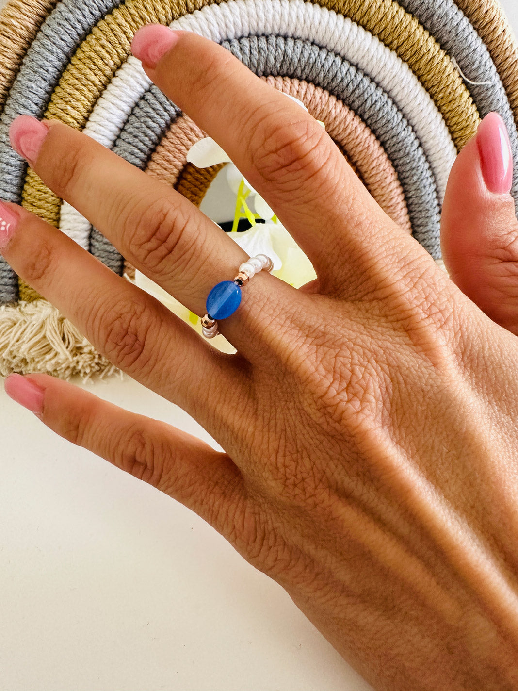 Anello elastico in argento 925 composto da perla colorata e piccole perle bianche. Dettaglio perla blu