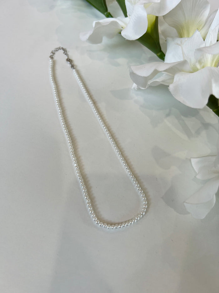 Collana in argento composta da perle sintetiche. Chiusura regolabile. Disponibile in 2 misure: S e M.