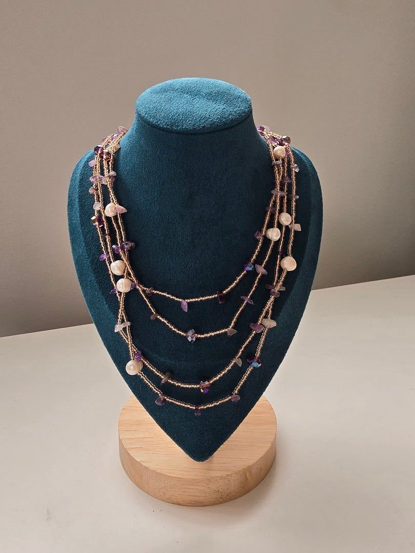 Collana lunga con pietre di diverse grandezze.