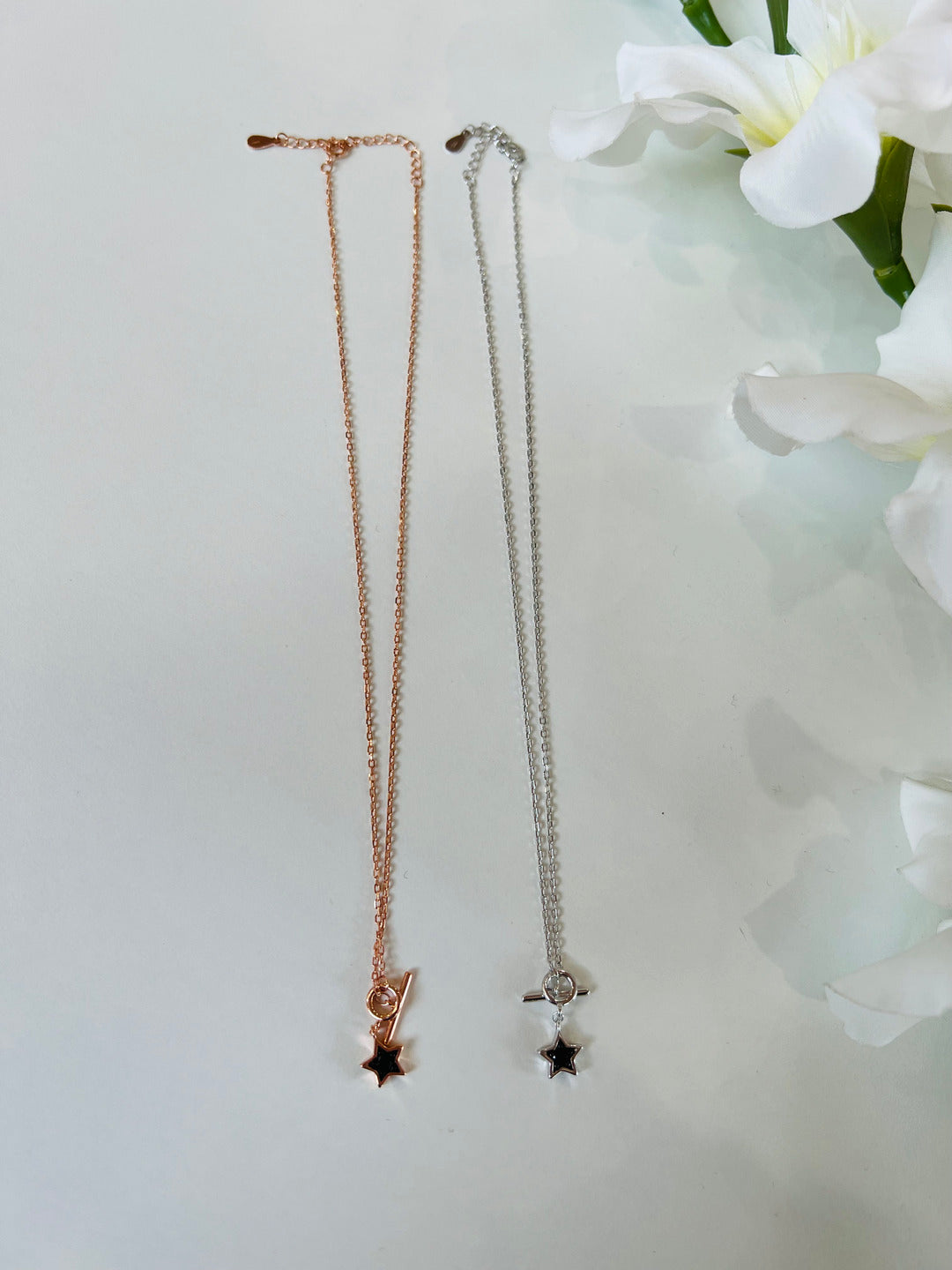 Collana composta da una catena sottile e pendente con stella nera. Chiusura regolabile. Disponibile in due colori: argento e oro rosa.