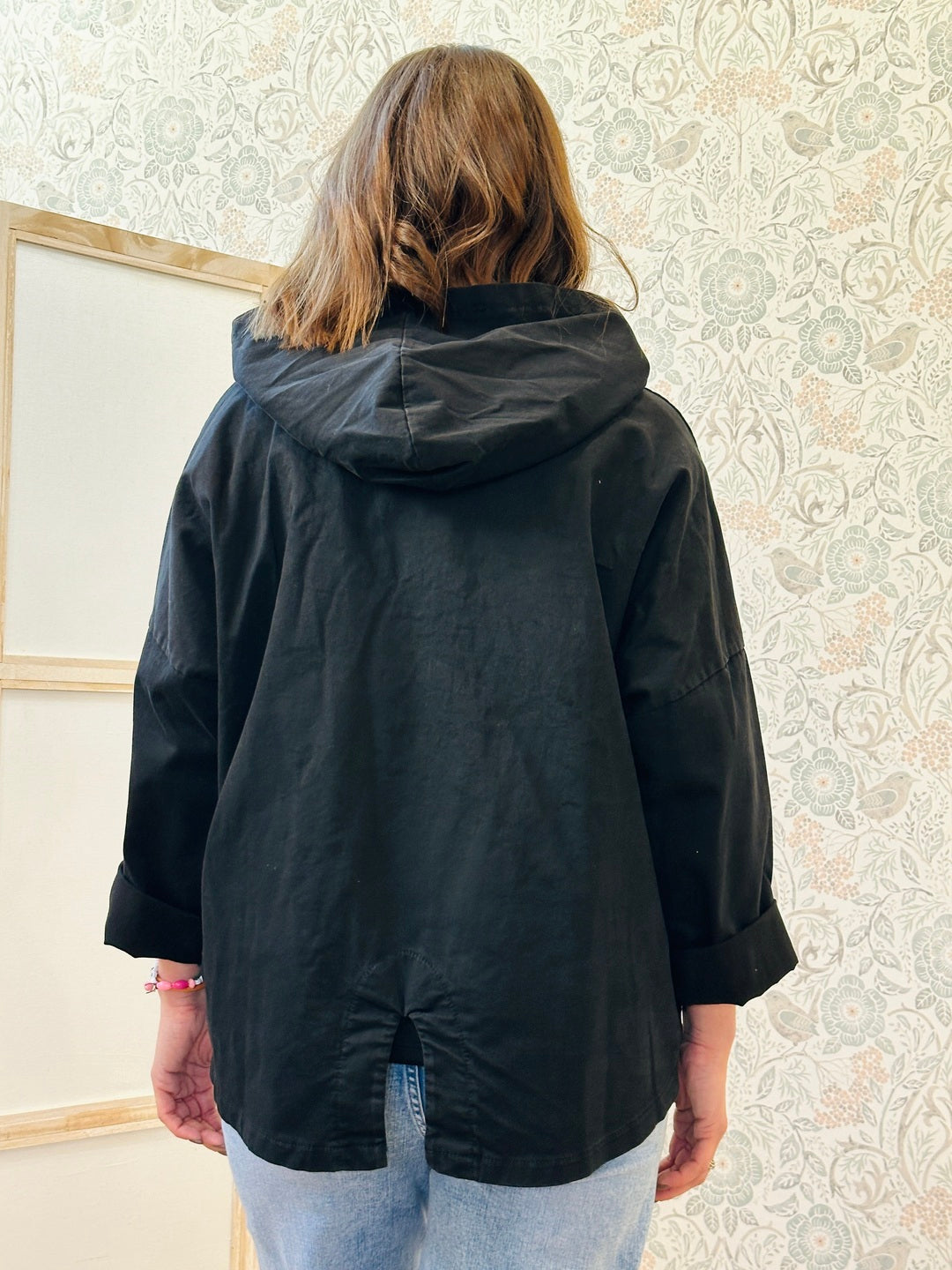 Parka nero leggero dotato di zip, tasconi e cappuccio.
