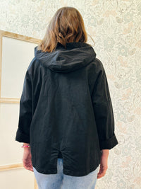 Parka nero leggero dotato di zip, tasconi e cappuccio.