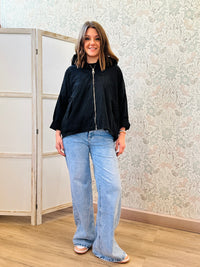 Parka nero leggero dotato di zip, tasconi e cappuccio.
