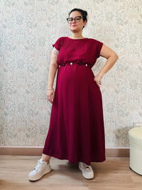 Abito lungo bordeaux con scollo tondo e manica corta. Cintura a nastro in vita regolabile con applicazioni. Vestibilità morbida e ampia. 