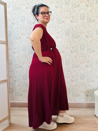 Abito lungo bordeaux con scollo tondo e manica corta. Cintura a nastro in vita regolabile con applicazioni. Vestibilità morbida e ampia. 
