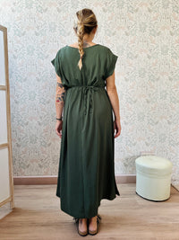 Abito lungo verde militare con scollo tondo e manica corta. Cintura a nastro in vita regolabile con applicazioni. Vestibilità morbida e ampia. 