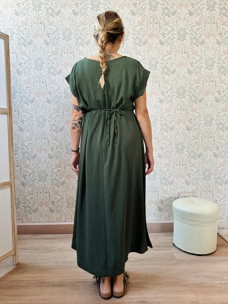 Abito lungo verde militare con scollo tondo e manica corta. Cintura a nastro in vita regolabile con applicazioni. Vestibilità morbida e ampia. 