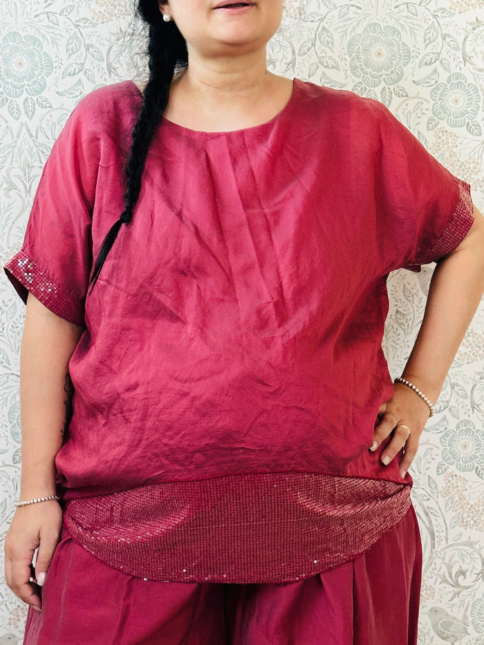 Blusa curvy a manica corta, scollo tondo profondo e top interno in fresca viscosa. Strass applicati sul bordo delle maniche e sul bordo finale del top. 
