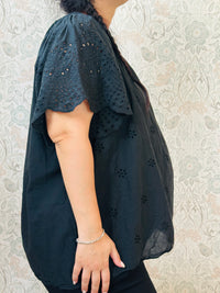 Blusa a manica corta con scollo tondo. Taglio svasato e ricami sangallo davanti. 
