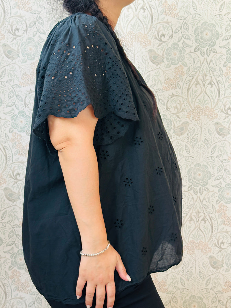 Blusa a manica corta con scollo tondo. Taglio svasato e ricami sangallo davanti. 