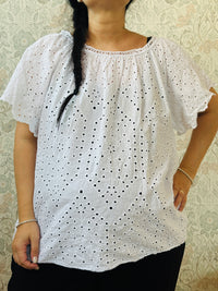 Blusa bianca, 100% viscosa, curvy, a manica corta con scollo tondo. Taglio svasato e ricami sangallo davanti. Taglia unica consigliata fino alla 54. 