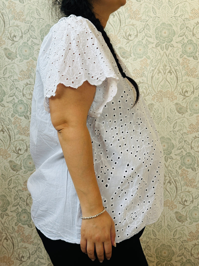 Blusa bianca, 100% viscosa, curvy, a manica corta con scollo tondo. Taglio svasato e ricami sangallo davanti. Taglia unica consigliata fino alla 54. 