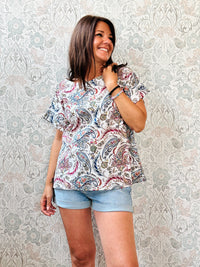 Blusa blu con fantasia, 100% cotone con scollo tondo ampio, manica corta e taglio svasato. Vestibilità morbida.