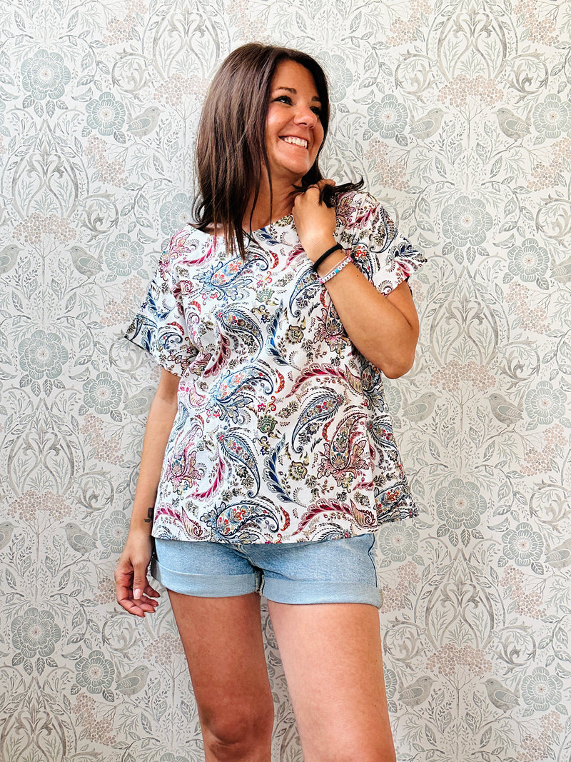 Blusa blu con fantasia, 100% cotone con scollo tondo ampio, manica corta e taglio svasato. Vestibilità morbida.