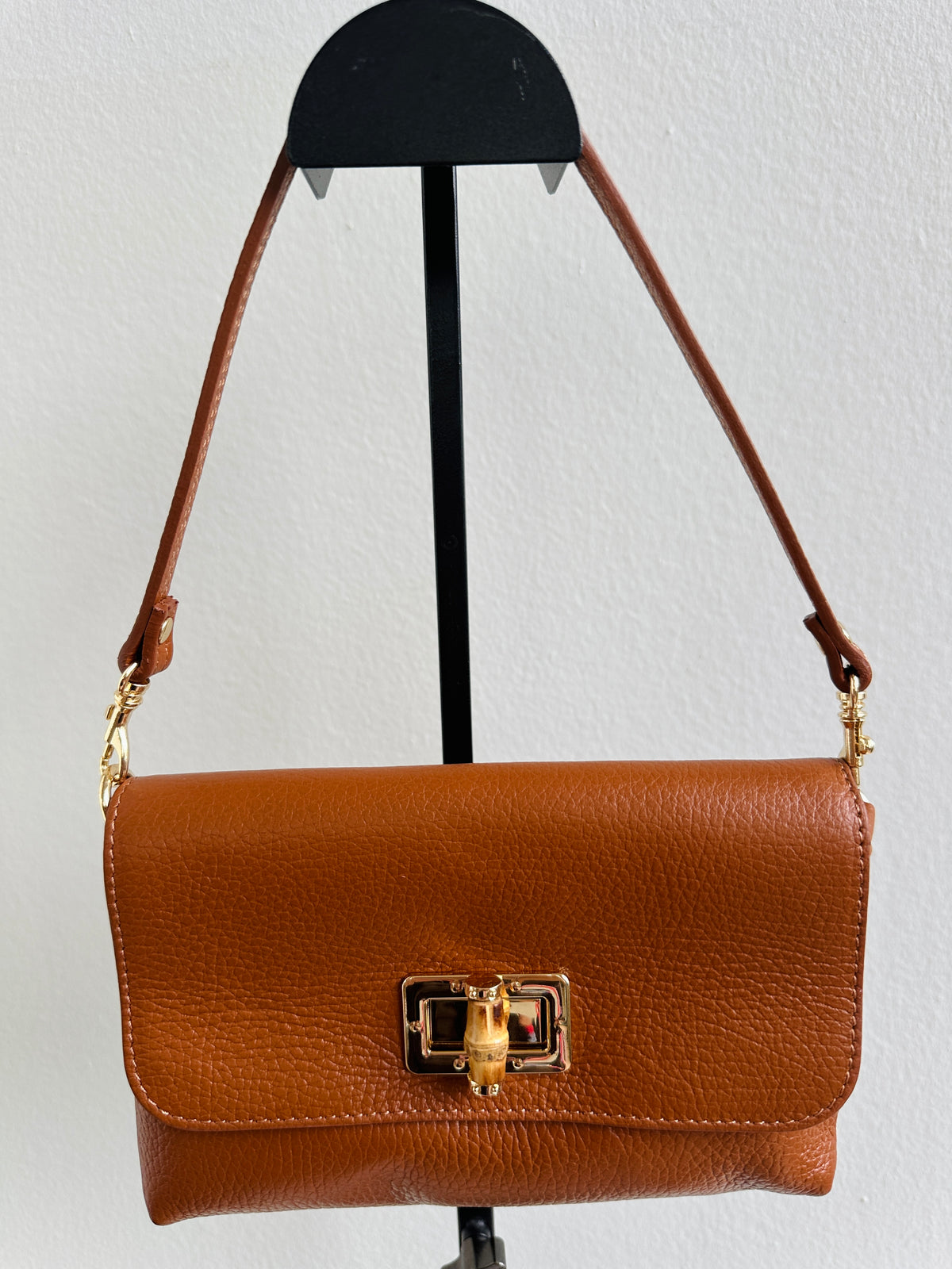 Borsa 100% pelle fiorentina con manico removibile in pelle e tracolla in catena dorata sottile removibile. Tasca unica e chiusura con gancio in corno.