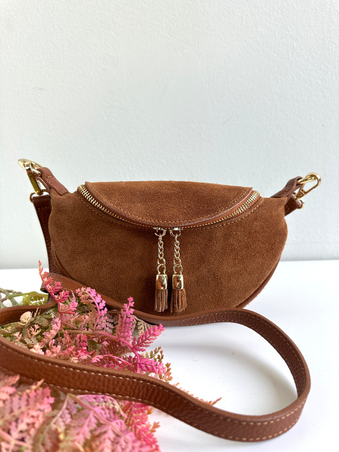 Borsa 100% pelle scamosciata a forma di mezzaluna. Chiusura con zip, tracolla regolabile e removibile.