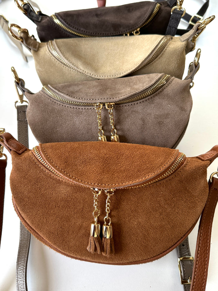 Borsa 100% pelle scamosciata a forma di mezzaluna. Chiusura con zip, tracolla regolabile e removibile. 