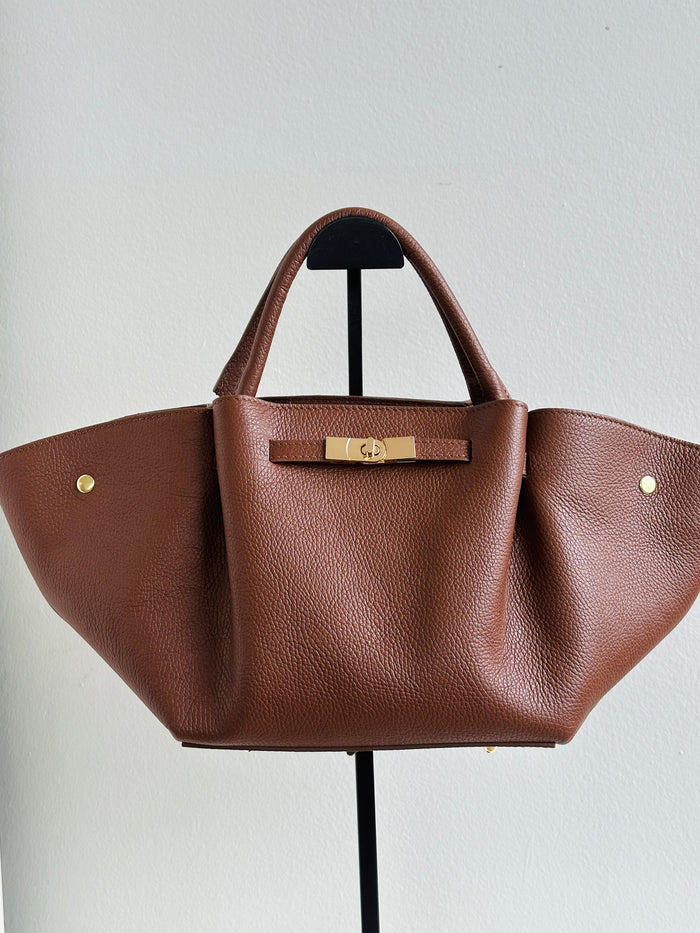 Borsa 100% pelle con manici a spalla, chiusura zip, tasca interna e tracolla regolabile. Colore marrone. 