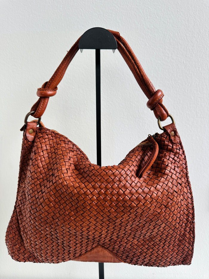 Borsa 100% pelle fiorentina intrecciata con manico a spalla. Tracolla regolabile e removibile. Tasca interna con zip. 