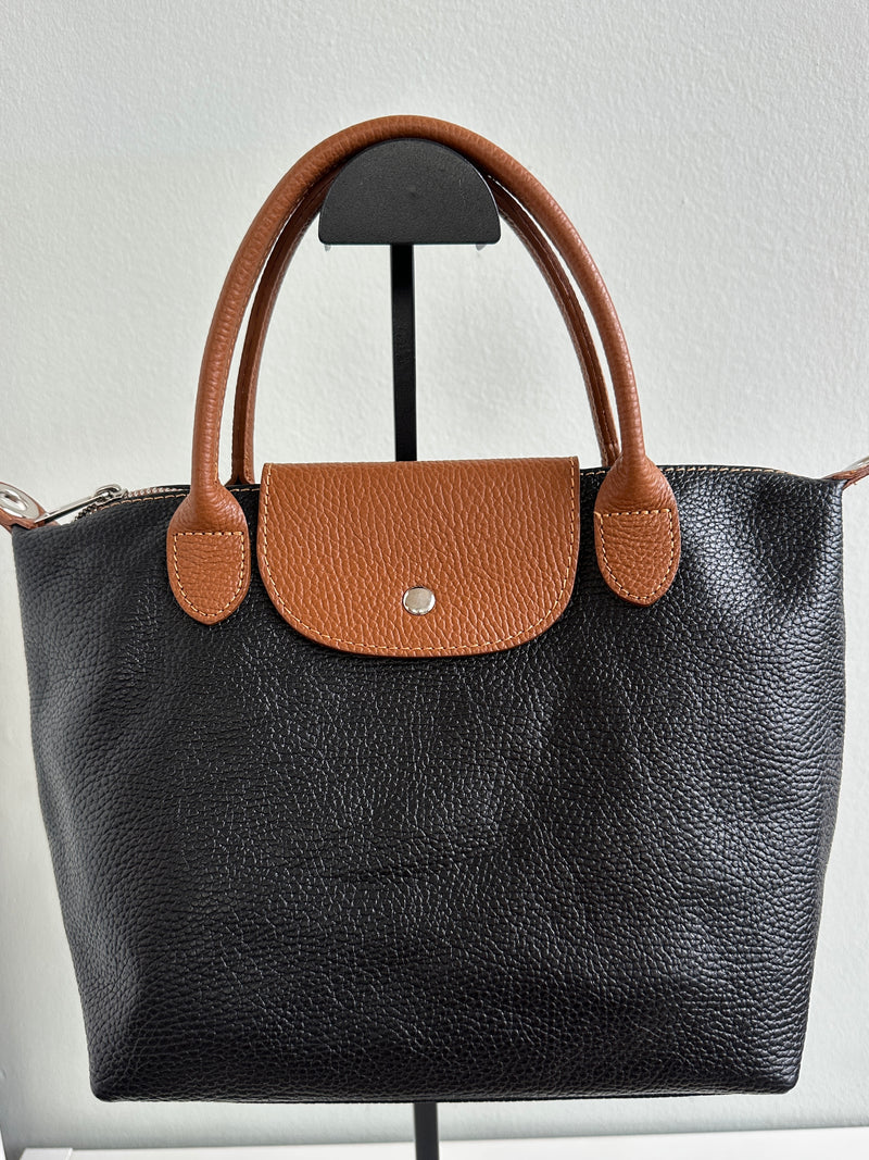 Borsa nera, 100% pelle fiorentina con manici a mano e chiusura con bottone a pressione color cuoio. Chiusura con zip, tasca interna, tracolla regolabile. 