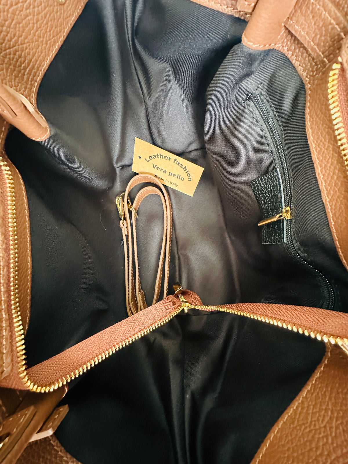 Borsa 100% pelle con manici a spalla, chiusura zip, tasca interna e tracolla regolabile. Colore marrone. 