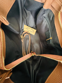 Borsa 100% pelle con manici a spalla, chiusura zip, tasca interna e tracolla regolabile. Colore marrone. 