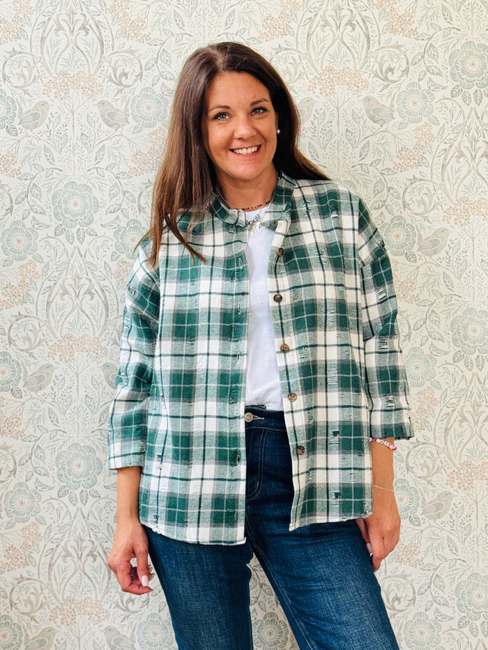Camicia a quadri con collo alla coreana e strappi decorativi. Taglio leggermente svasato e vestibilità morbida. 