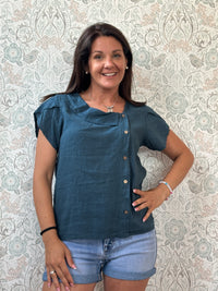 Camicia a manica corta con scollo a barchetta, colletto laterale e dettaglio linea con bottoni decorativi. 
