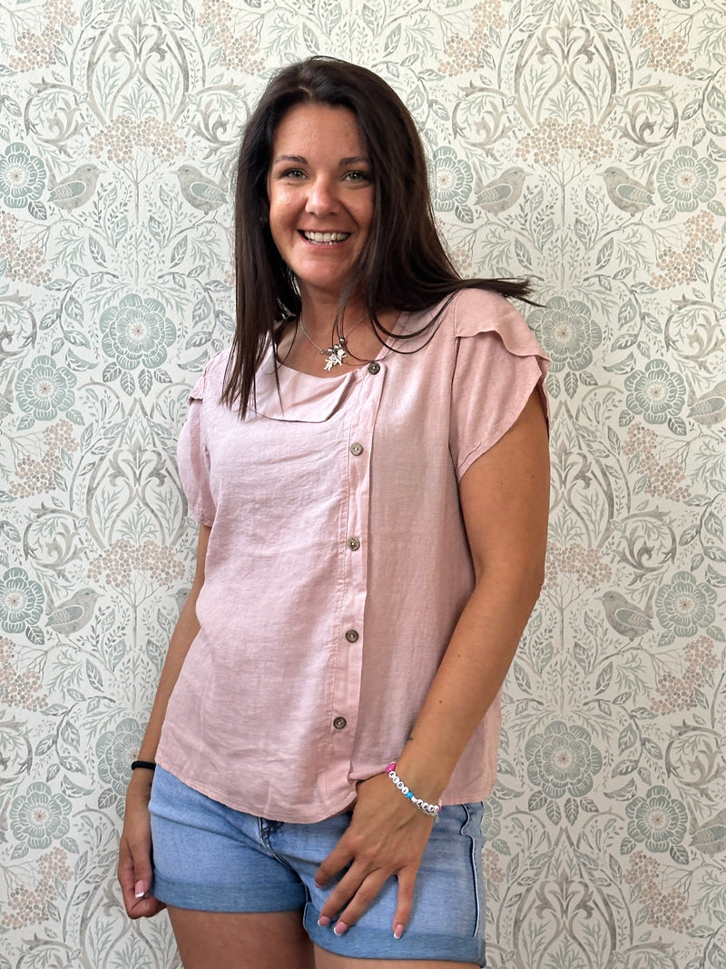 Camicia a manica corta con scollo a barchetta, colletto laterale e dettaglio linea con bottoni decorativi. 