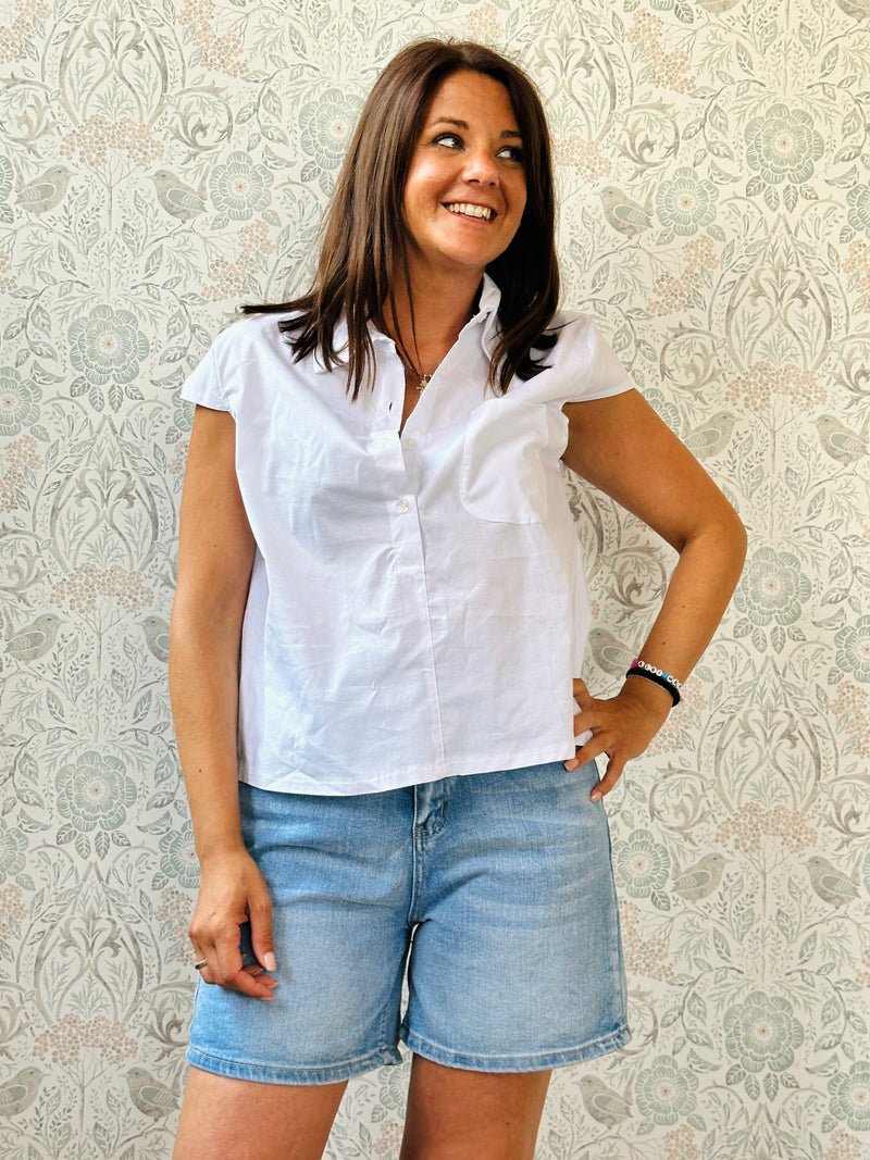 Camicia a manica corta con bottoni e tasca sul davanti. Colore: bianco. 