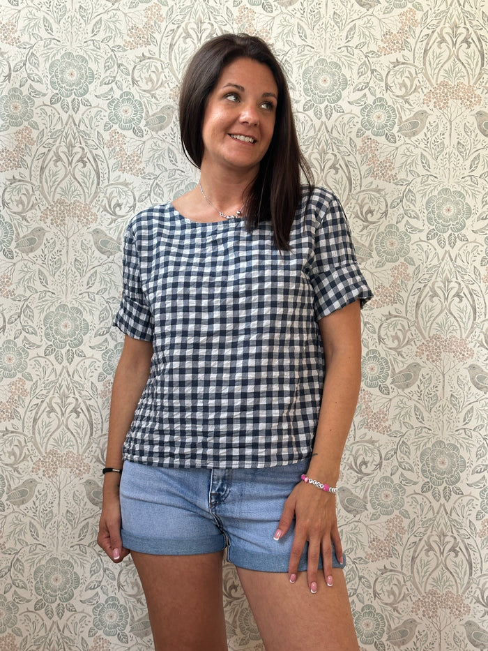 Camicia 100% lino, manica 3/4 con scollo tondo ampio. Bottoni sul retro e taglio leggermente svasato.
