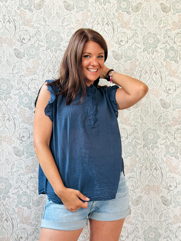 Camicia blu, 100% cotone con maniche corte, volant e bottoncini apribili. Collo alla coreana. 