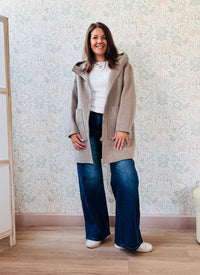 Cappotto beige, taglio dritto e ampio con chiusura zip, cappuccio e tasche sul davanti a viste e aperte. 