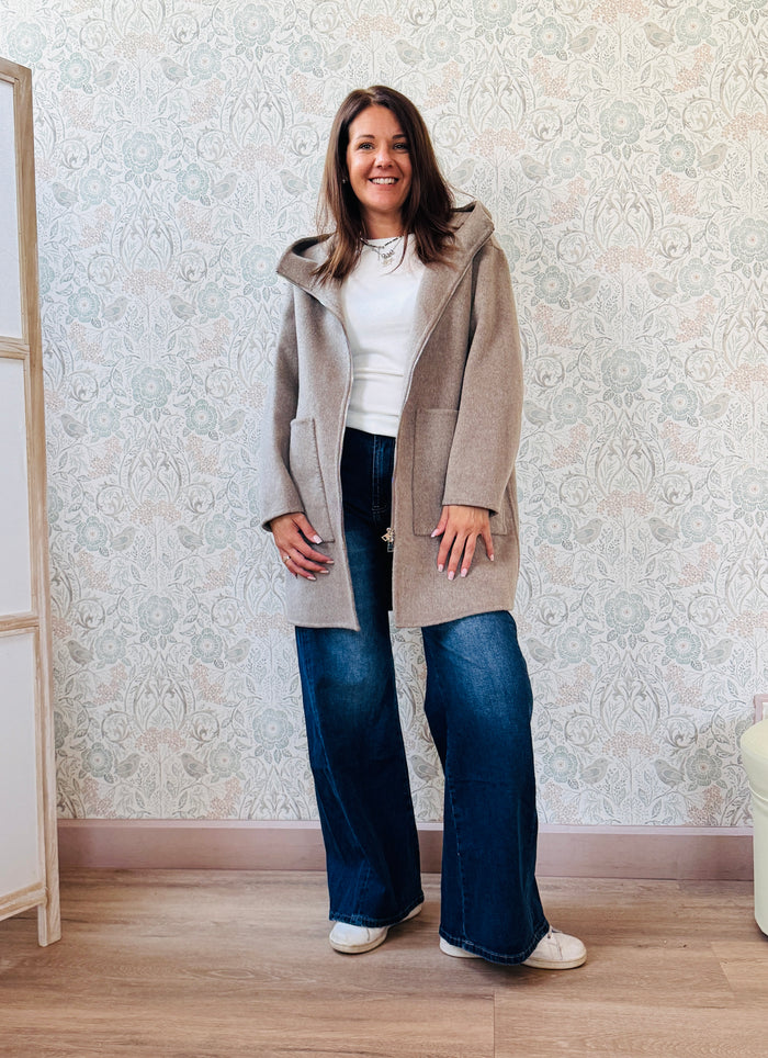Cappotto beige, taglio dritto e ampio con chiusura zip, cappuccio e tasche sul davanti a viste e aperte. 