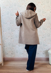 Cappotto beige, taglio dritto e ampio con chiusura zip, cappuccio e tasche sul davanti a viste e aperte.  