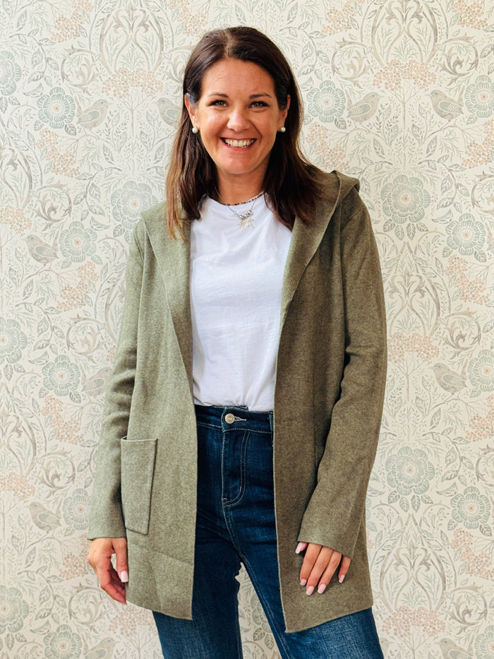 Cardigan da donna lungo con cappuccio e tasche a vista aperte sul davanti. 