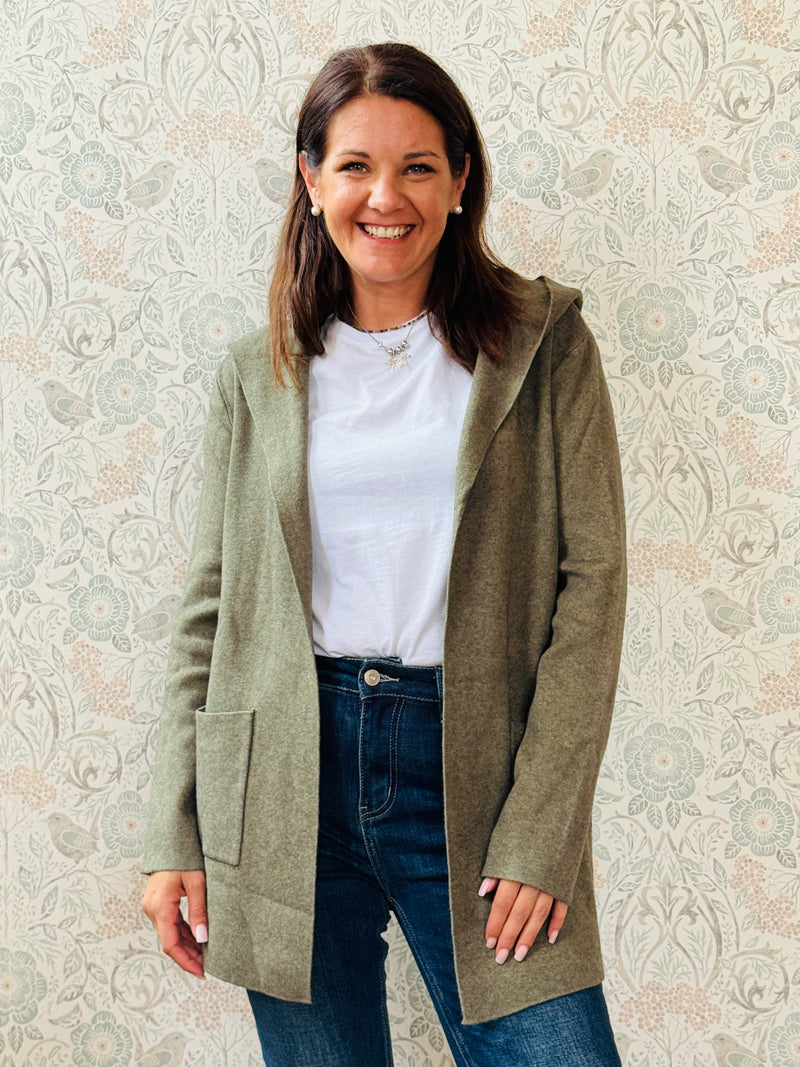 Cardigan da donna lungo con cappuccio e tasche a vista aperte sul davanti. 