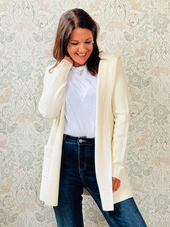 Cardigan da donna lungo con cappuccio e tasche a vista aperte sul davanti.  