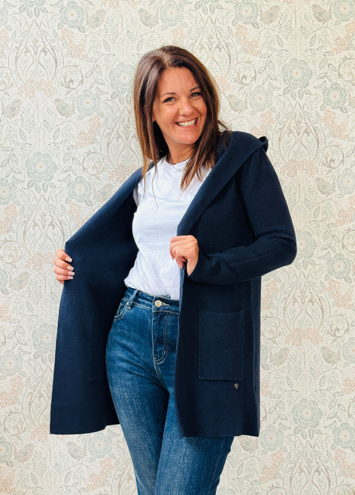 Cardigan da donna lungo con cappuccio e tasche a vista aperte sul davanti. 