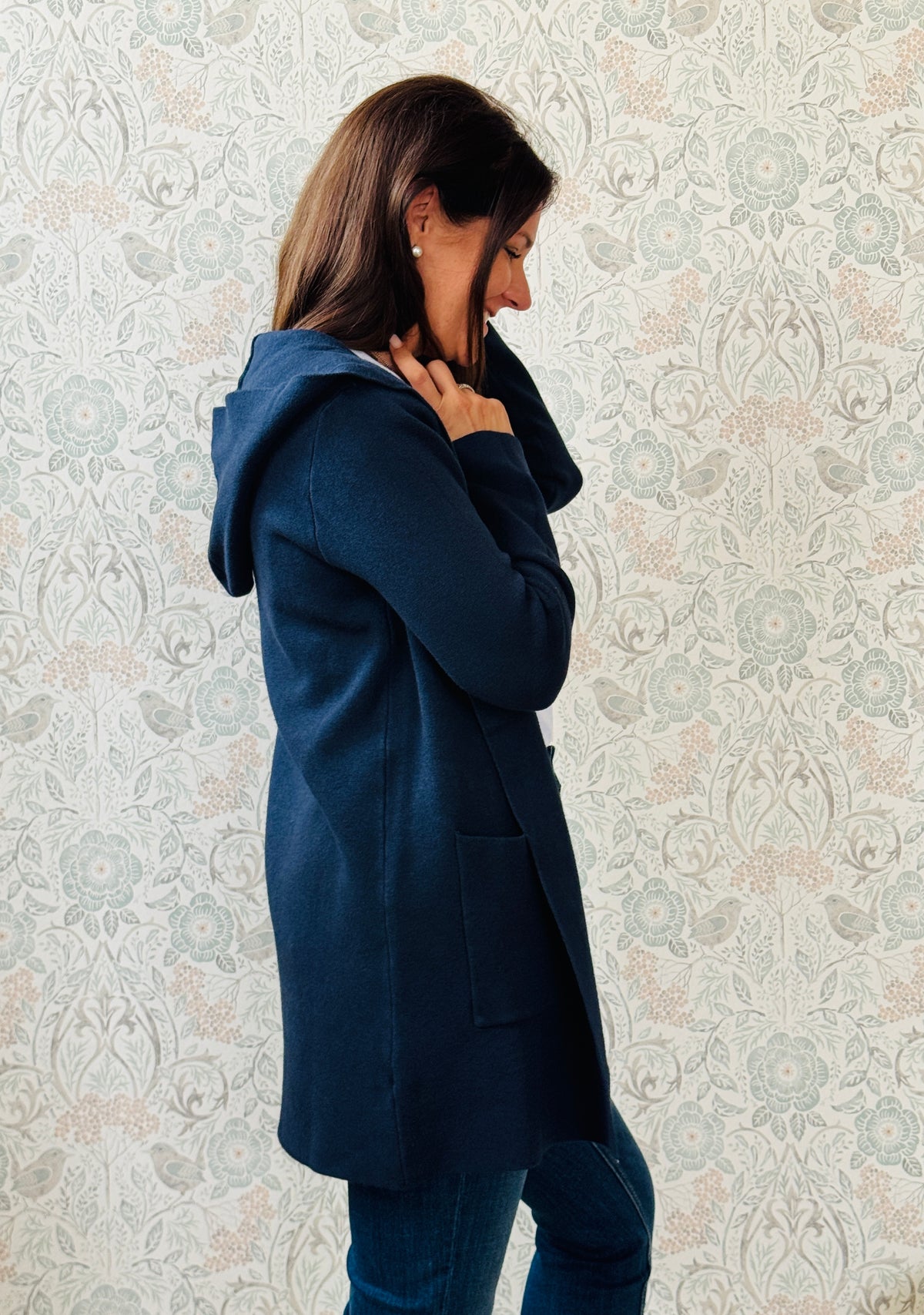 Cardigan da donna lungo con cappuccio e tasche a vista aperte sul davanti. 