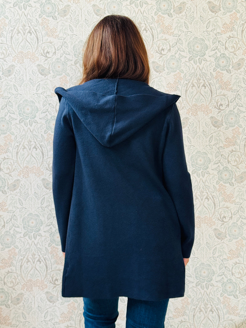 Cardigan da donna lungo con cappuccio e tasche a vista aperte sul davanti. 