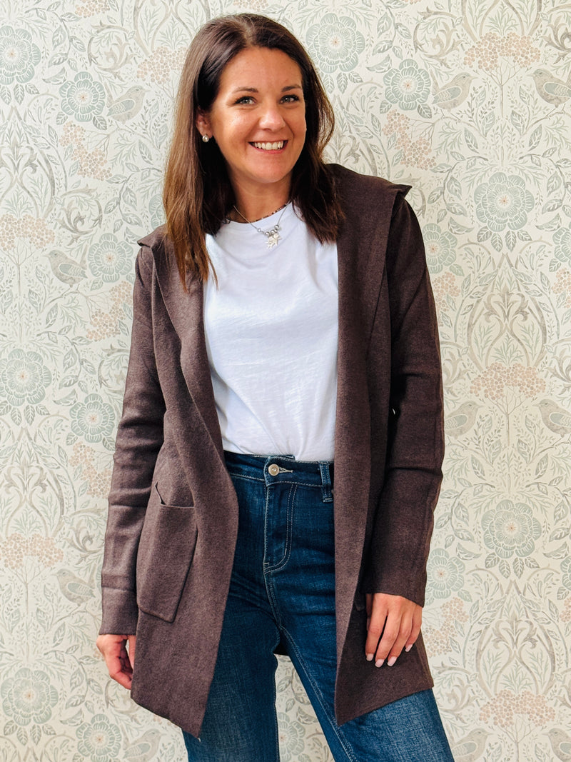 Cardigan da donna lungo con cappuccio e tasche a vista aperte sul davanti. 