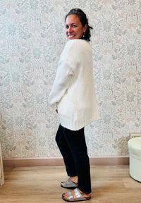 Cardigan aperto con trama grossa e tasche a vista. Vestibilità mordida e ampia. 