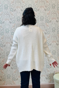 Cardigan aperto con trama grossa e tasche a vista. Vestibilità mordida e ampia.  