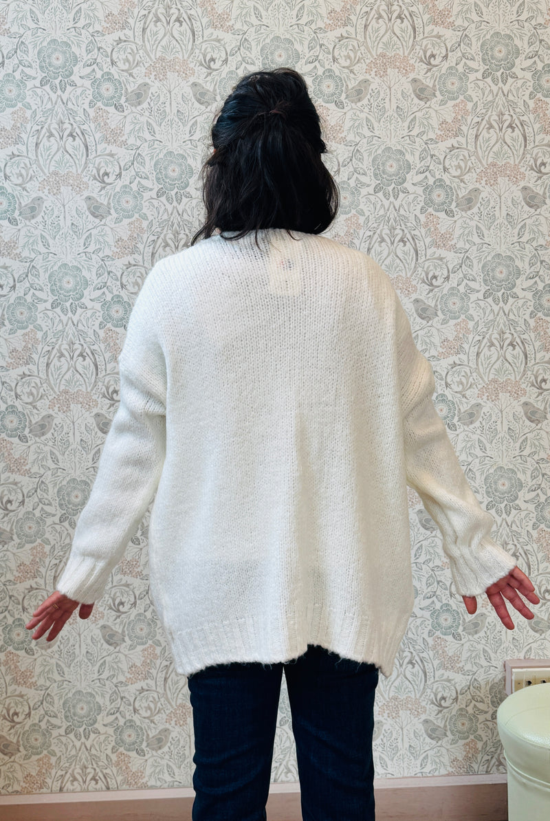 Cardigan aperto con trama grossa e tasche a vista. Vestibilità mordida e ampia.  