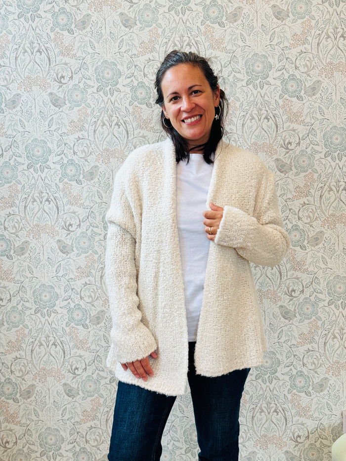 Cardigan misto lana corto aperto con vestibilità ampia e morbida. Disponibile nei colori bianco e nero.  