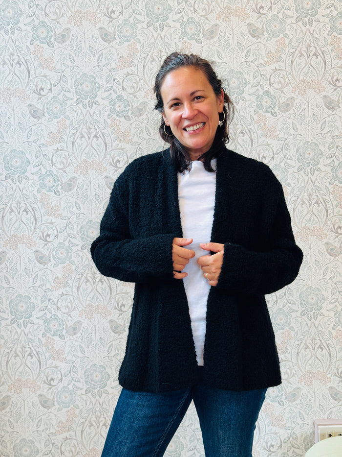 Cardigan misto lana corto aperto con vestibilità ampia e morbida. Disponibile nei colori bianco e nero. 