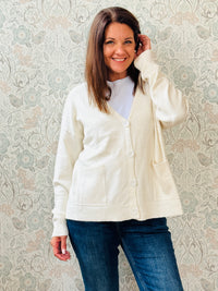 Cardigan da donna, scollo a V profondo con bottoni e tasche laterali a vista. 