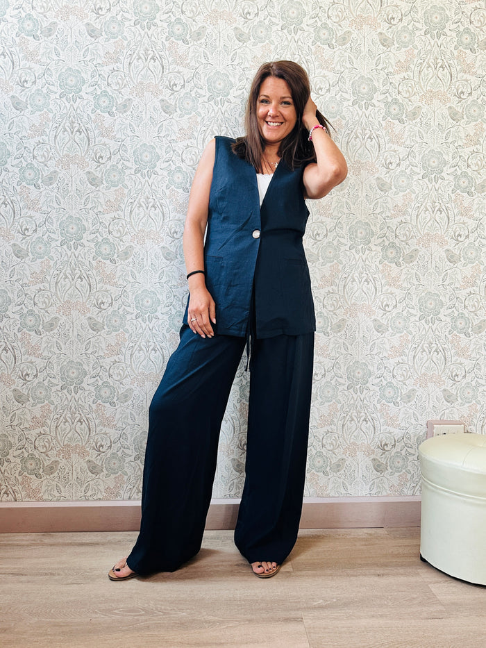 Completo Carrie Blu: Completo composto da pantalone a palazzo  e gilet senza maniche lungo con chiusura ad unico bottone.