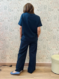 Completo composto da blusa a mezza manica e pantaloni larghi e comodi sulla gamba.